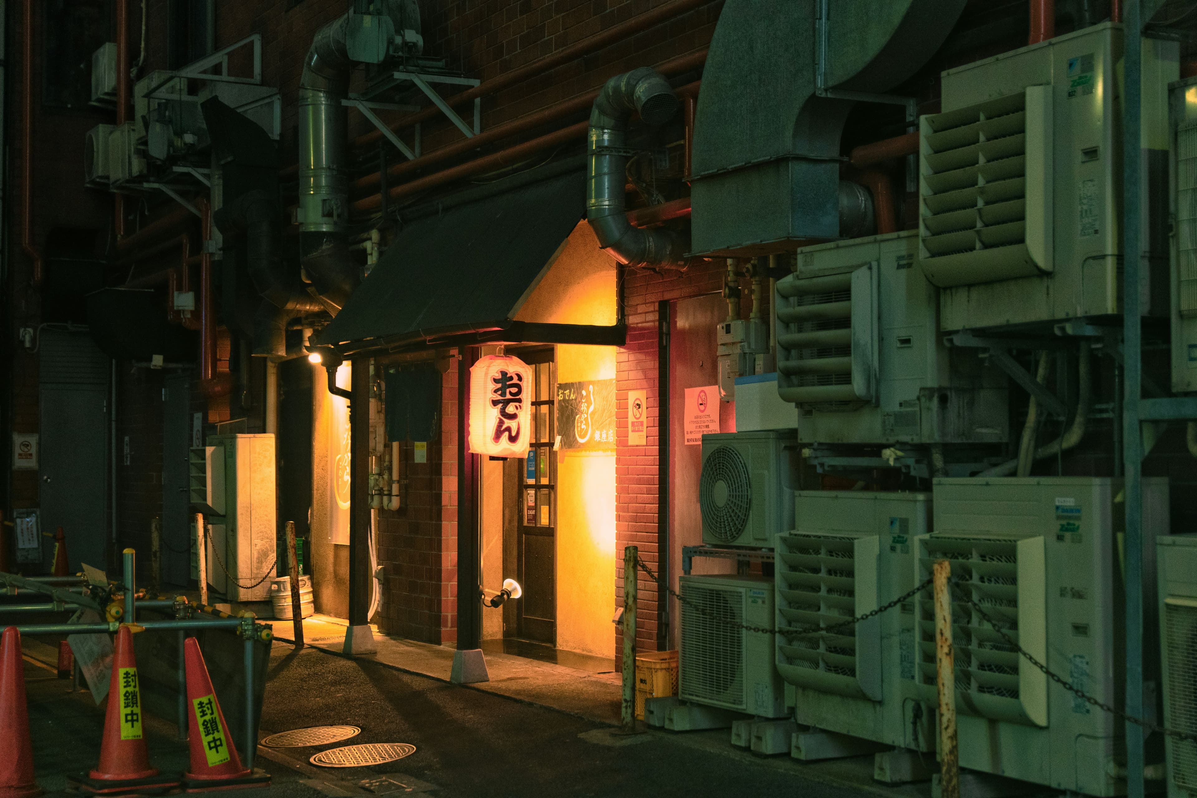 A lantern-lit oden shop on a narrow Tokyo street at night